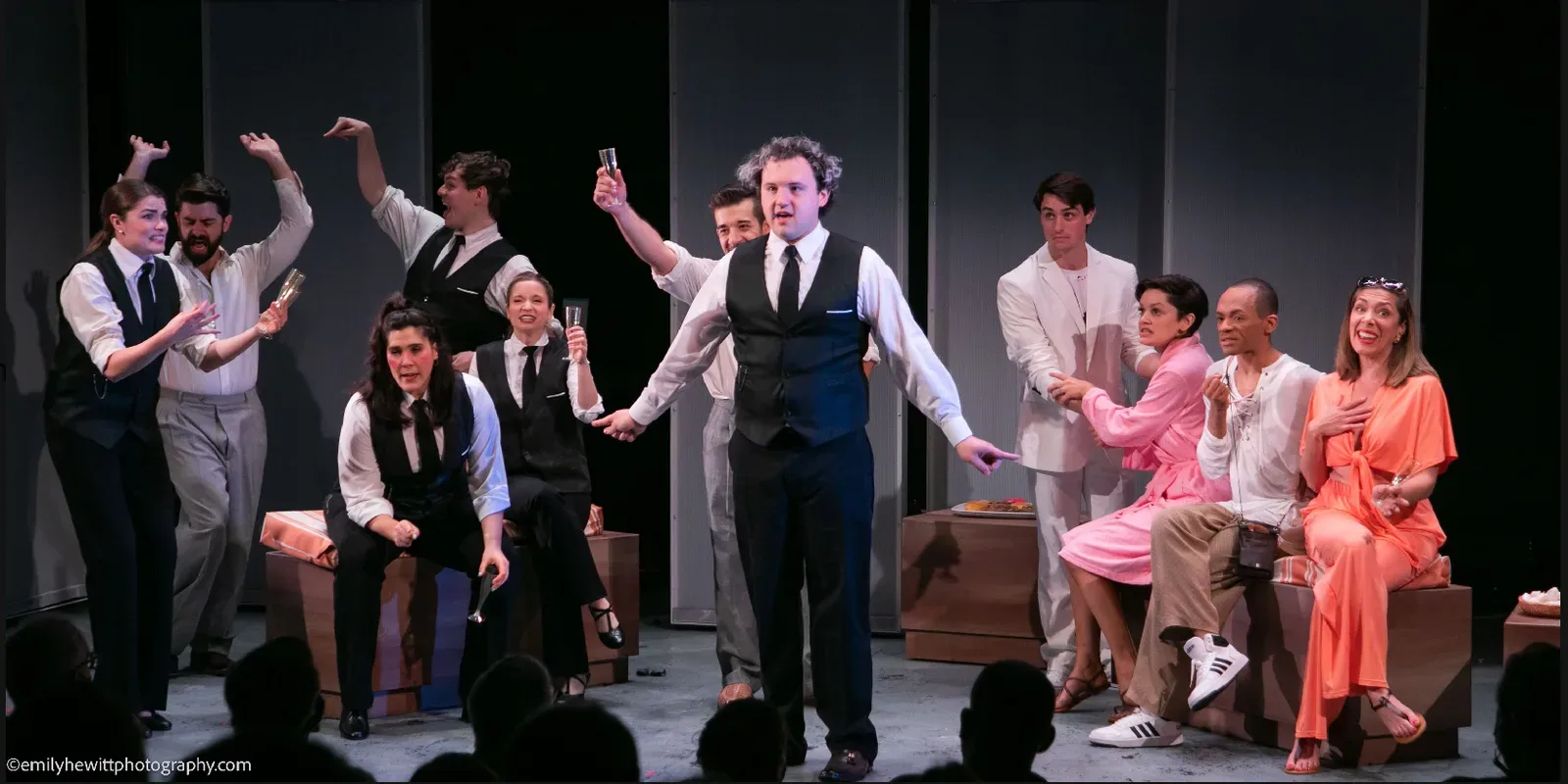 The full company raising a toast on stage